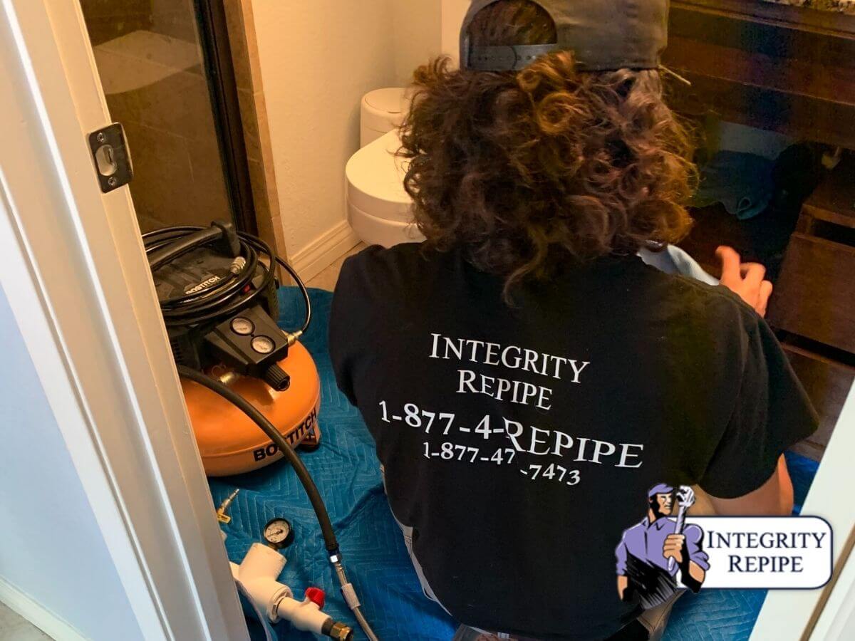 Integrity´s plumber technician  repairing a bathroom pipe